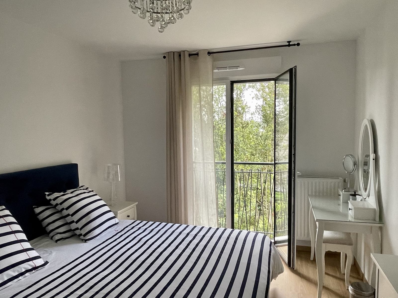 Master bedroom with king-size bed and French window onto the garden